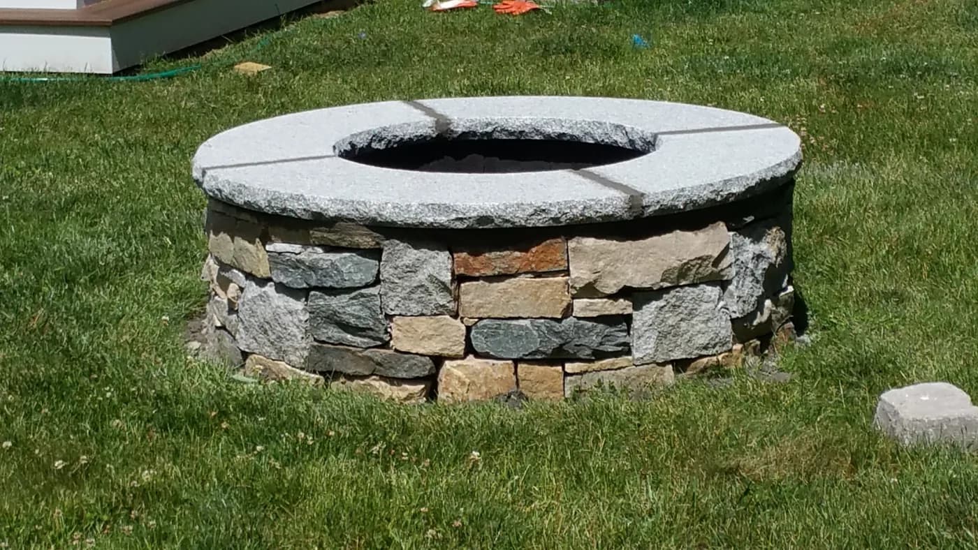 Natural stone fire pit with a granite cap ring