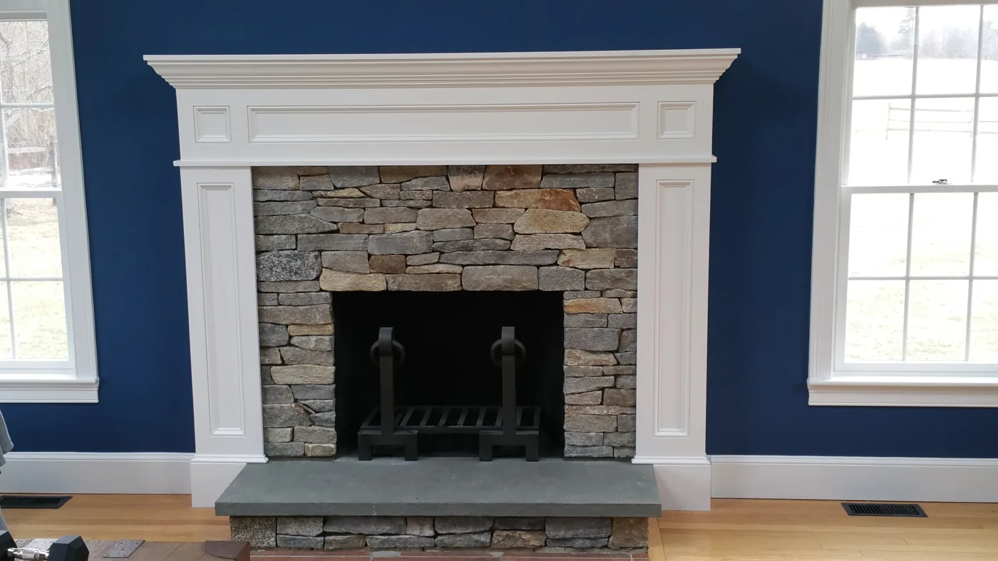 Finished stone fireplace with a painted mantel