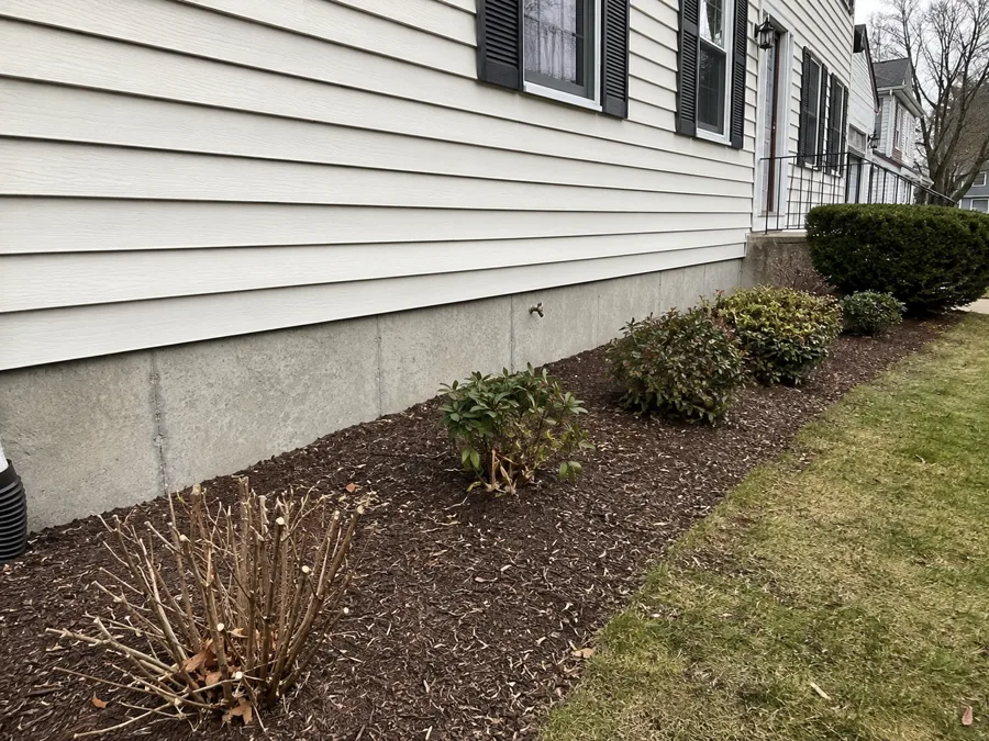 Homeowner's photo of a bare concrete foundation strip below the siding