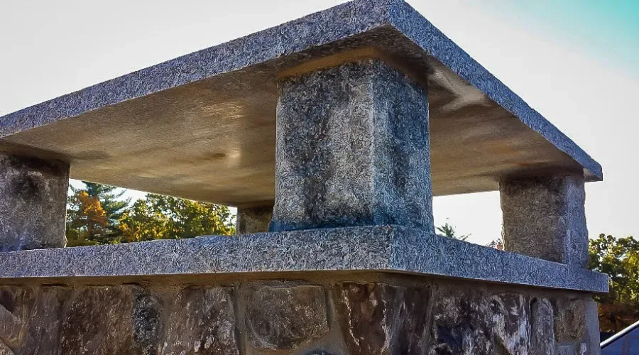 Restored stone chimney with a new granite crown by JB Mohler Masonry