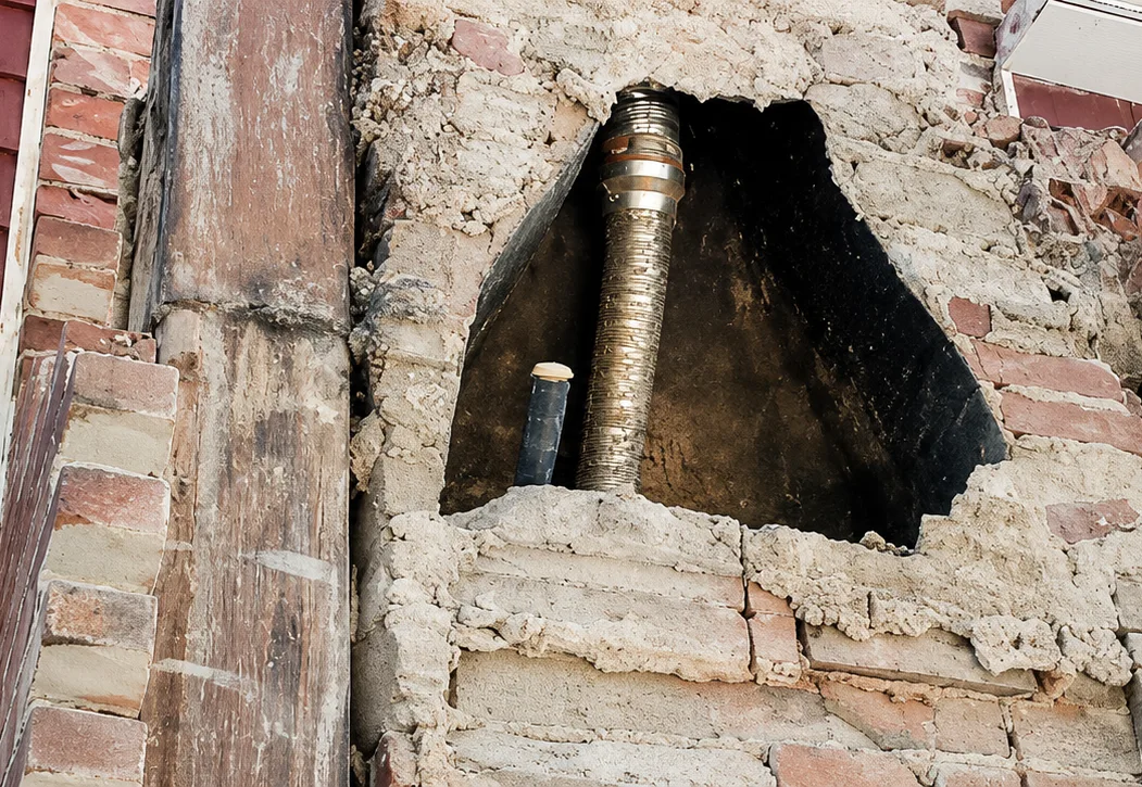Chimney opened up mid-rebuild, exposing the flue liner inside the brick stack