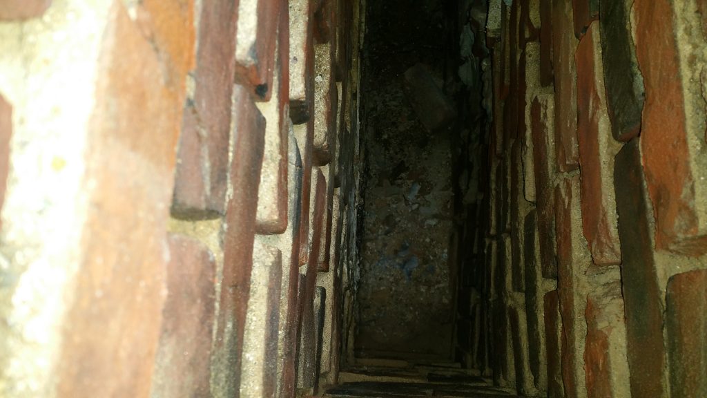 chimney interior with no clay flue liner and exposed brick masonry