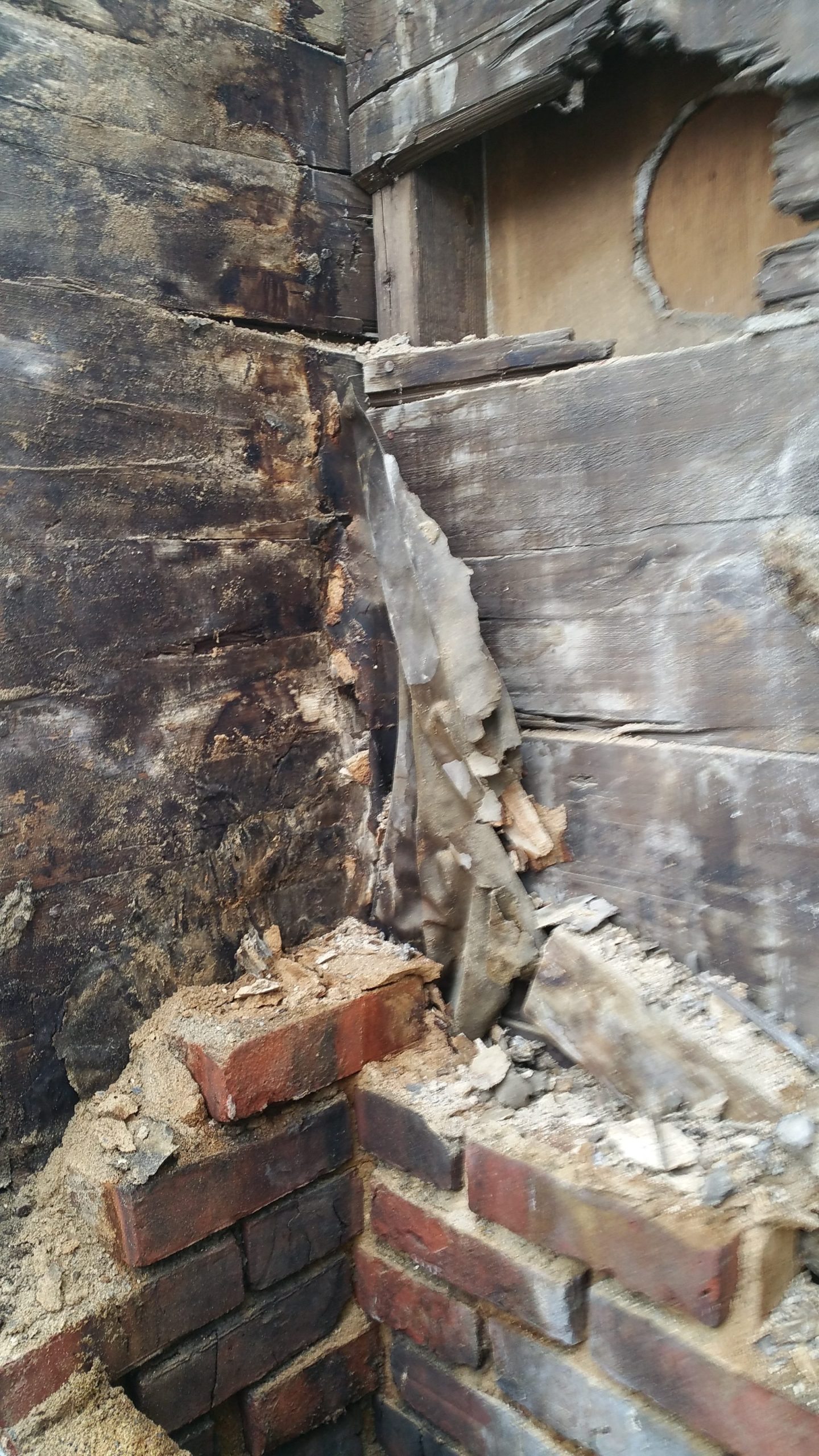 rotted wood sheathing behind chimney caused by poor moisture protection