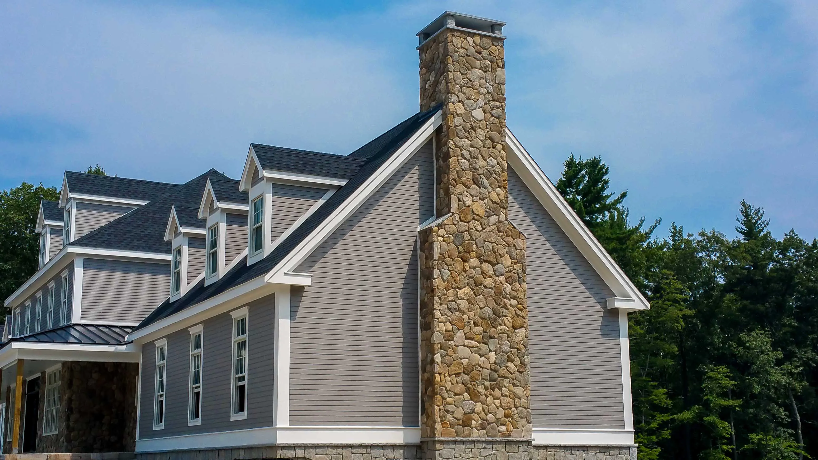 Stone masonry chimney with metal cap on a Groton, Massachusetts home